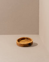 olive wood bowl with rich grain pattern, displayed against a dark background.